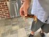 A person holds a crab in an outdoor structure.