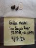 Two golden mussels sit on a paper towel on a table next to a dime, which is similar in size to the mussels.